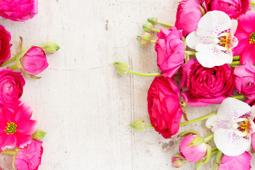 Floral composition - frame made of ranunculus flowers on white wooden background. Flat lay, top view, copy space on paper tag