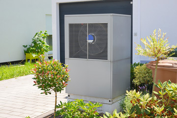 Luftwärmepumpe für Heizung und Warmwasser vor einem Mehrfamilienhaus