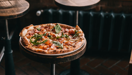 Pizza carbonara on rustic wooden table at the restaurant. Food photography concept. Copyspace