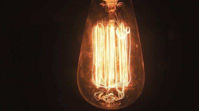 Retro Edison light bulb closeup dramatic entry in the frame