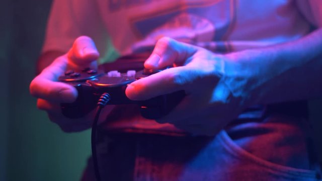 Retro gamer in the 80s 90s using a controller to play a video game. Neon lighting arcade style