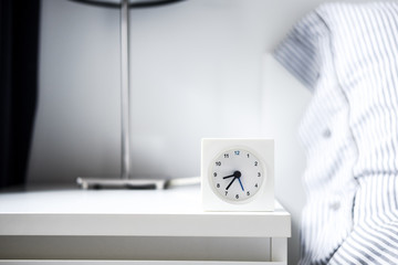 Alarm clock in white bedroom iterior
