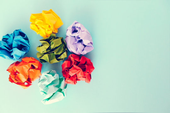 Colorful crumpled paper balls on blue background