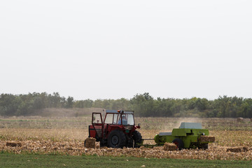 Fototapeta premium a red tractor on a field in autumn