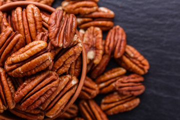 delicious pecan nuts on a dark stone background