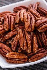 delicious pecan nuts on a rustic wooden background