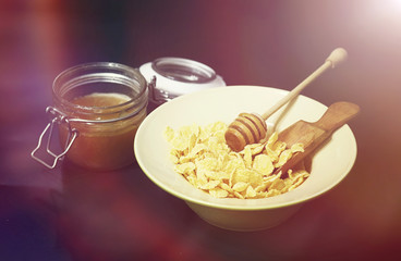 Corn flakes in a plate. Breakfast from flakes with honey and mil