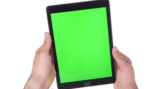 Tablet device with a green screen being hold in hands without any gestures on pure 100% white background.