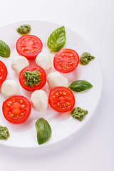 Caprese salad on a white acrylic background