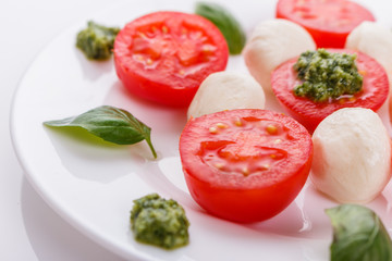Caprese salad on a white acrylic background