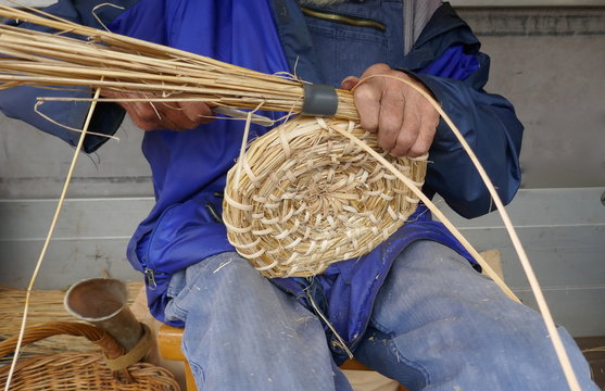 Alter Mann beim Herstellen  eines Bienenkorbes nach alter Tradition

