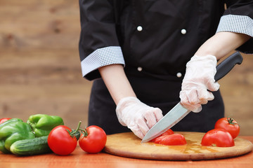 The cook cuts fresh farm vegetables