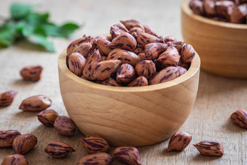 Roasted striped peanuts in wooden bowl