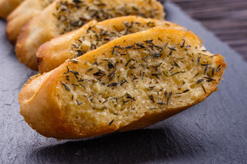 fragrant garlic bread on a dark stone plate