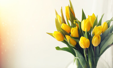 A bouquet of red tulips in a vase on the windowsill. A gift for 