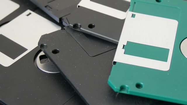 Close up view of many inch computer floppy disks or diskette scattered on flat surface vintage technology