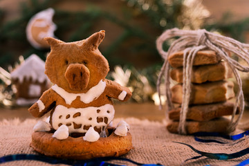 Cookie dough in the form of a pig-the symbol of 2019 pig, on the background of Christmas decorations.