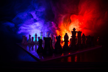 Fototapeta na wymiar Chess board game concept of business ideas and competition or strategy ideas concept. Chess figures on a dark toned foggy background.