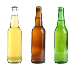 Set with different cold beer bottles on white background