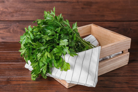 Crate with fresh green parsley on wooden table