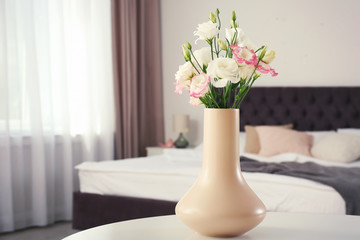 Beautiful flowers in vase and space for text on blurred background. Element of interior design