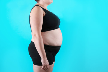 Fototapeta premium Fat woman on color background, space for text. Weight loss