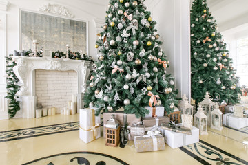 Presents and Gift boxes under Christmas Tree. Beige boxes with ribbon bow. New year decorated house interior. Winter Holiday concept.