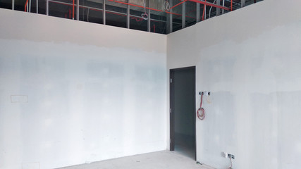 Drywall installation work in progress by construction workers at the construction site. It is the...