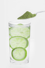 Moringa powder with lemon and glass with water isolated on white background