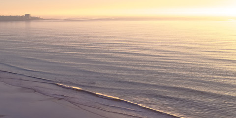 Ocean at Blacks Beach with sunset in the horizon