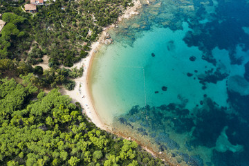 Spectacular aerial view of a beautiful wild beach bathed by a clear and turquoise sea, Sardinia, Italy.