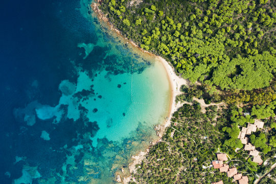 Spectacular aerial view of a beautiful wild beach bathed by a clear and turquoise sea, Sardinia, Italy.