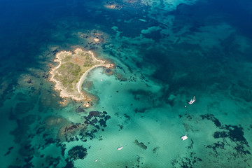 Spectacular aerial view of a little island bathed by a clear and turquoise sea, Sardinia, Italy.