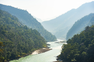 Spectacular view of the sacred Ganges river flowing through the green mountains of Rishikesh,...