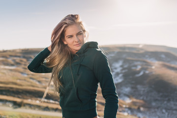 Young fit woman exercising on a mountain top