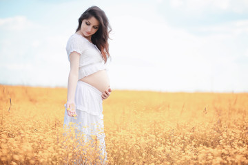 Pregnant woman in nature for a walk in the autumn