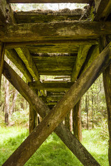 Old disused timber railway bridge in bushland near Daylesford, Victoria, Australia