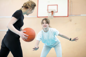 Girl in the gym playing a basketball