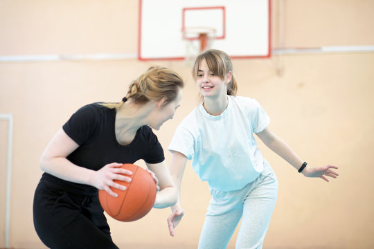 Girl in the gym playing a basketball