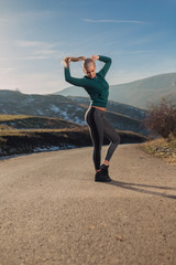 Young fit woman exercising on a mountain top