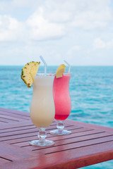Two tropical fresh juices on wooden table.