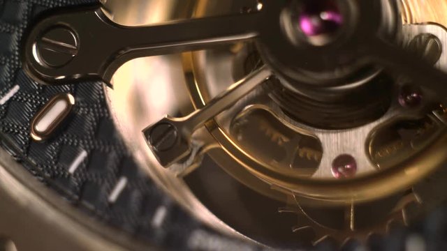 Mechanism of a watch with jewels. Open clockwork and fragments of shiny gears. Close up 4k macro shot. Time and work concept.