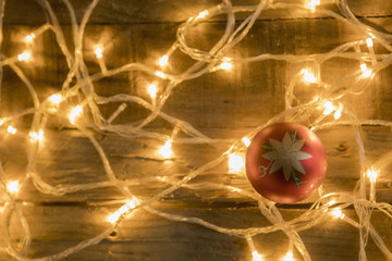 Christmas ornament and christmas lights on vintage wooden background