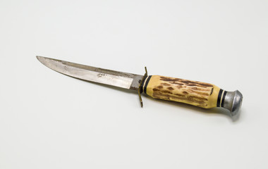 vintage hunting knife with brown and yellow handle isolated on white
