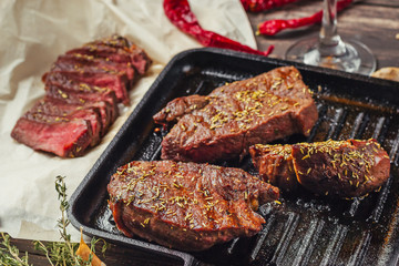 Grilled beef steak on frying pan, top view. Fried chunks of meat close up