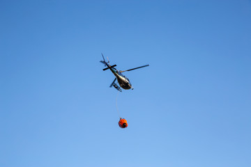 Helicopter fighting BC forest fires during a hot sunny summer day. Taken near Port Alice, Northern Vancouver Island, British Columbia, Canada.