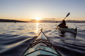 Girl Sea Kayaking during a vibrant sunny summer sunset. Taken in Vancouver, BC, Canada. - obrazy, fototapety, plakaty