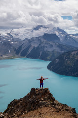 Woman standing on top of the Mountain overlooking a beautiful glacier lake. Taken on Panorama...