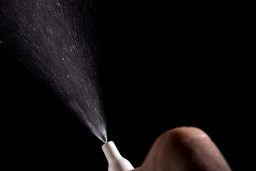 Spray for nose sprayed in the air on a black background