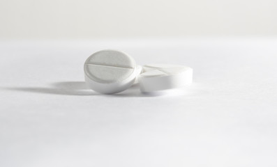 White tablets lie and jump against a white background